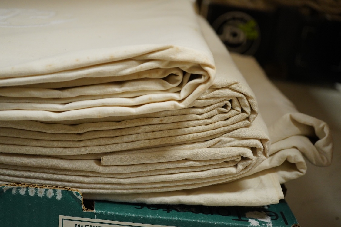 Seven French provincial coarse linen sheets, with a drawn thread bordered large white monogrammed turn backs